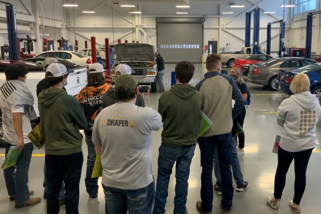 Visitors tour the auto tech lab on campus