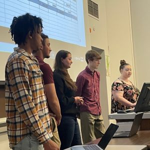 A group of five students presenting on their project