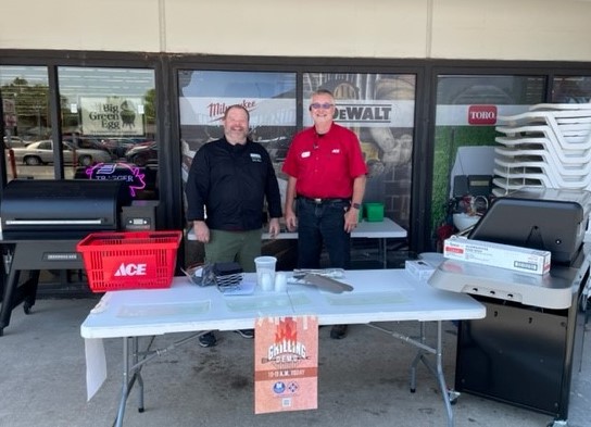 Josh Dineen and Ace representative with grill in front of store