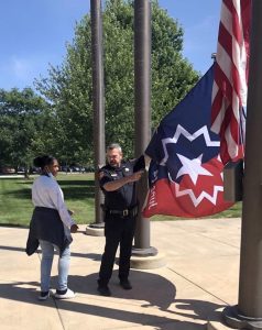 Chief Russell raising flag with NextLevel youth