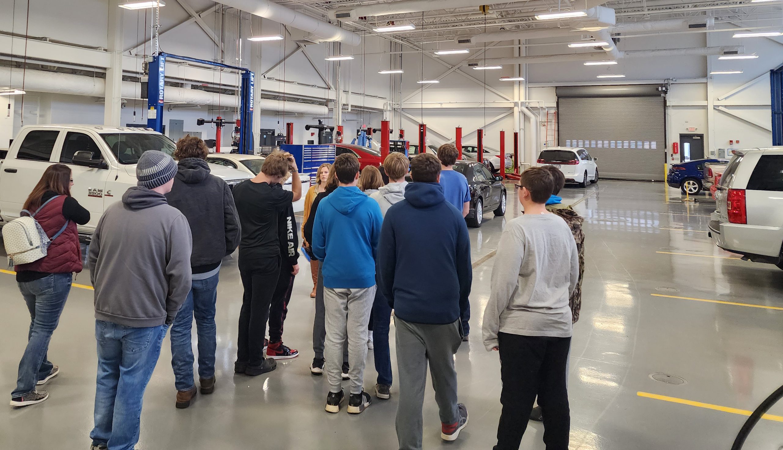 An LLCC recruiter speaking to a group of students in the auto tech lab