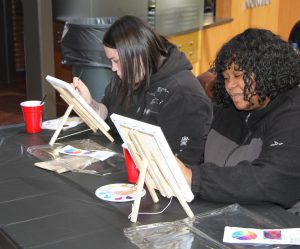 Participants painting on canvas