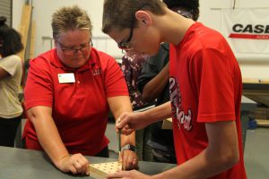 Dr. Lesley Frederick assisting Career Launch teens with wood peg game project