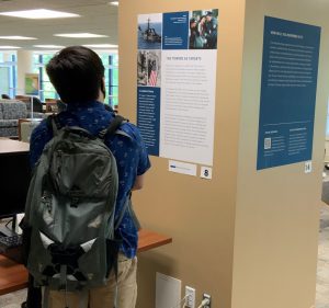 Student looking at 9/11 poster on library pillar