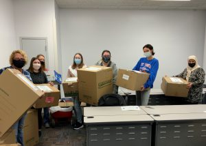 Dr. Hosseinali and students holding the packed boxes for donation
