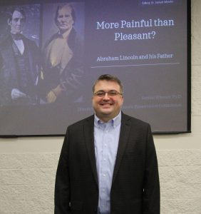 Dr. Samuel Wheeler standing in front of his opening presentation slide