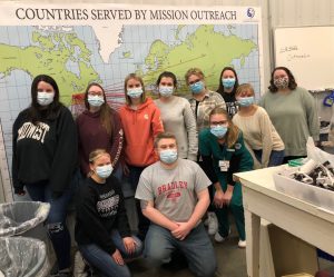 Student Radiographer Association club members in front a world map saying "Countries served by mission outreach"
