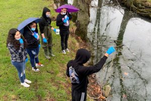 Student sampling water out of Lake Macoupin