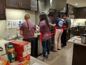 Four IV Leaguer students preparing a meal in the kitchen