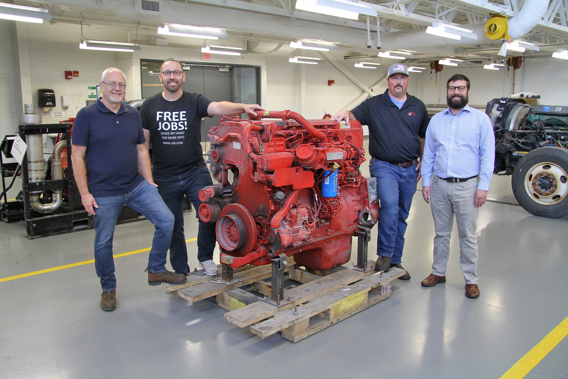 Jeff Gardner, director, LLCC diesel technologies program; Nick Stafford, talent acquisition lead, JX Enterprises, Inc.; Jarried Knoll, service manager, JX Truck Center-Bloomington; and Josh Collins, assistant vice president, business relations, LLCC with a Cummins ISX15 engine donated to LLCC as a teaching tool by JX Truck Center-Bloomington.