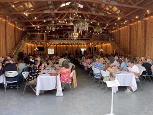 Events guests at tables in a barn