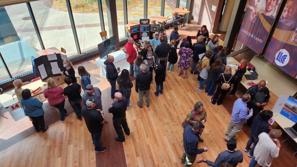 photo looking down on employees interacting with Assessment Fair displays