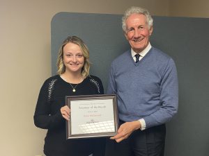 Katie McDannald receiving a certificate for volunteer of the month recognition