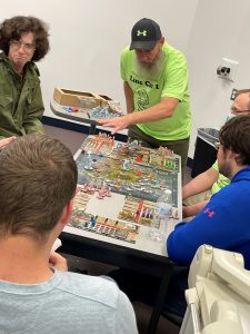 Faculty and students playing a board game