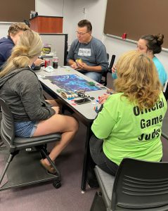 Two faculty playing a board game with students