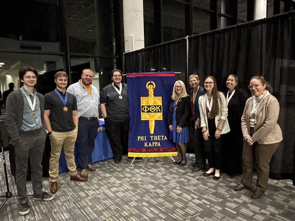 PTK officers and advisors in front of PTK banner