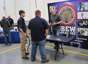 Two students talking to rep from IBEW Local 193
