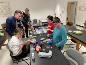 Professor showing four students how to play a game