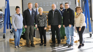 Eight LLCC and John Deere officials standing in diesel tech lab