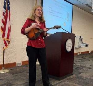 Jennifer Ramm holding mandolin while presenting in Trutter Center