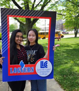 Two students holding the Loggers picture frame