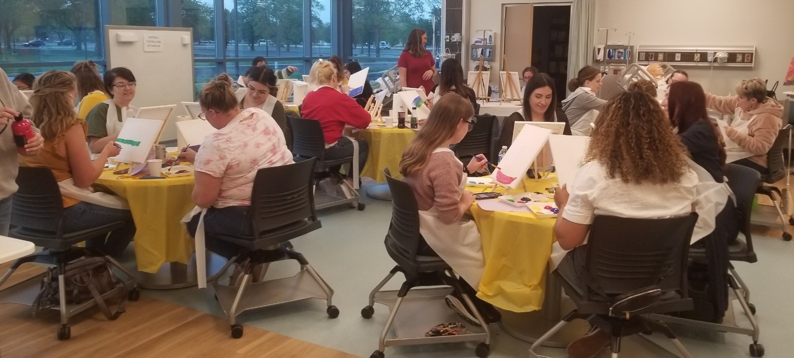 Participants sitting at tables painting