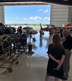 View from inside hangar, including planes, equipment and out through open door