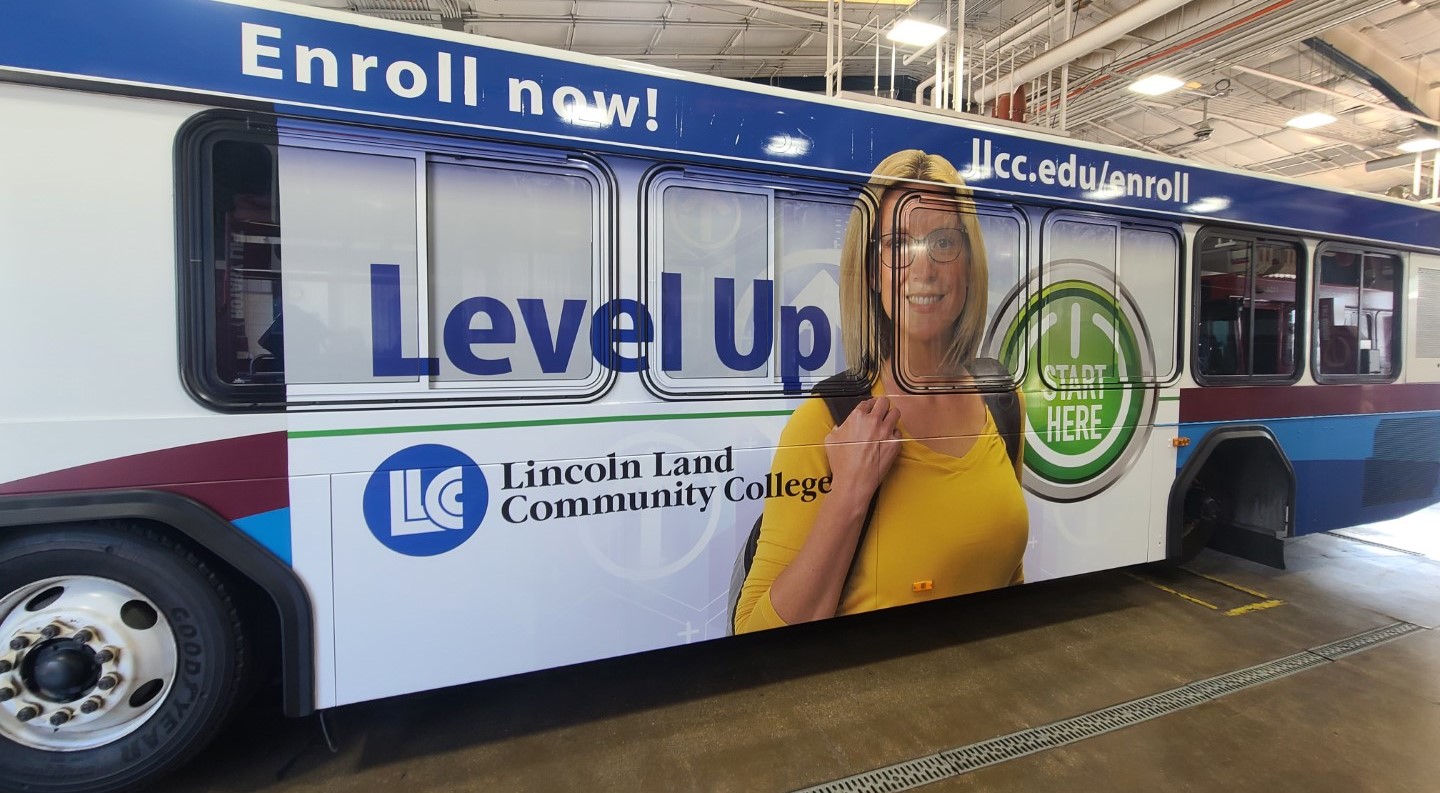 On side of bus: Level Up. Start Here button. Lincoln Land Community College. Enroll now! llcc.edu/enroll