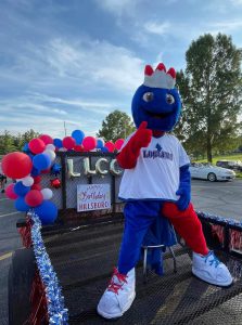 Linc sitting on parade float, which include sign saying, "Happy birthday Hillsboro"