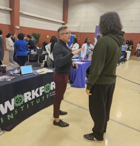 Jeff Martin talking to a student at the Workforce Institute table.