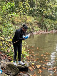 Student collecting sample from creek
