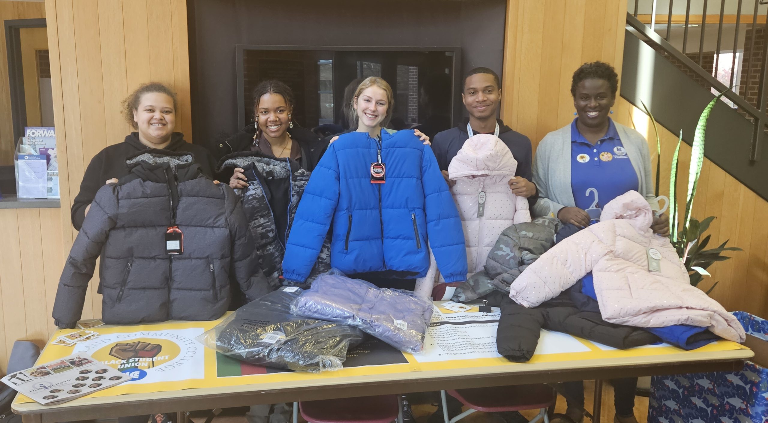 Members of BSU and PTK collecting coats at table in A. Lincoln Commons