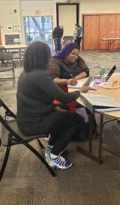 Kim Wilson assisting a student at a study table