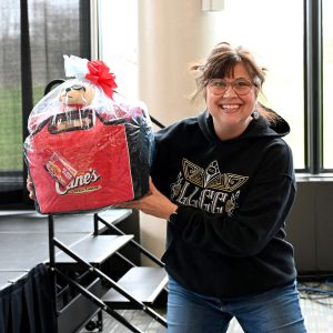 An LLCC employee posing with the Raising Canes basket she won.