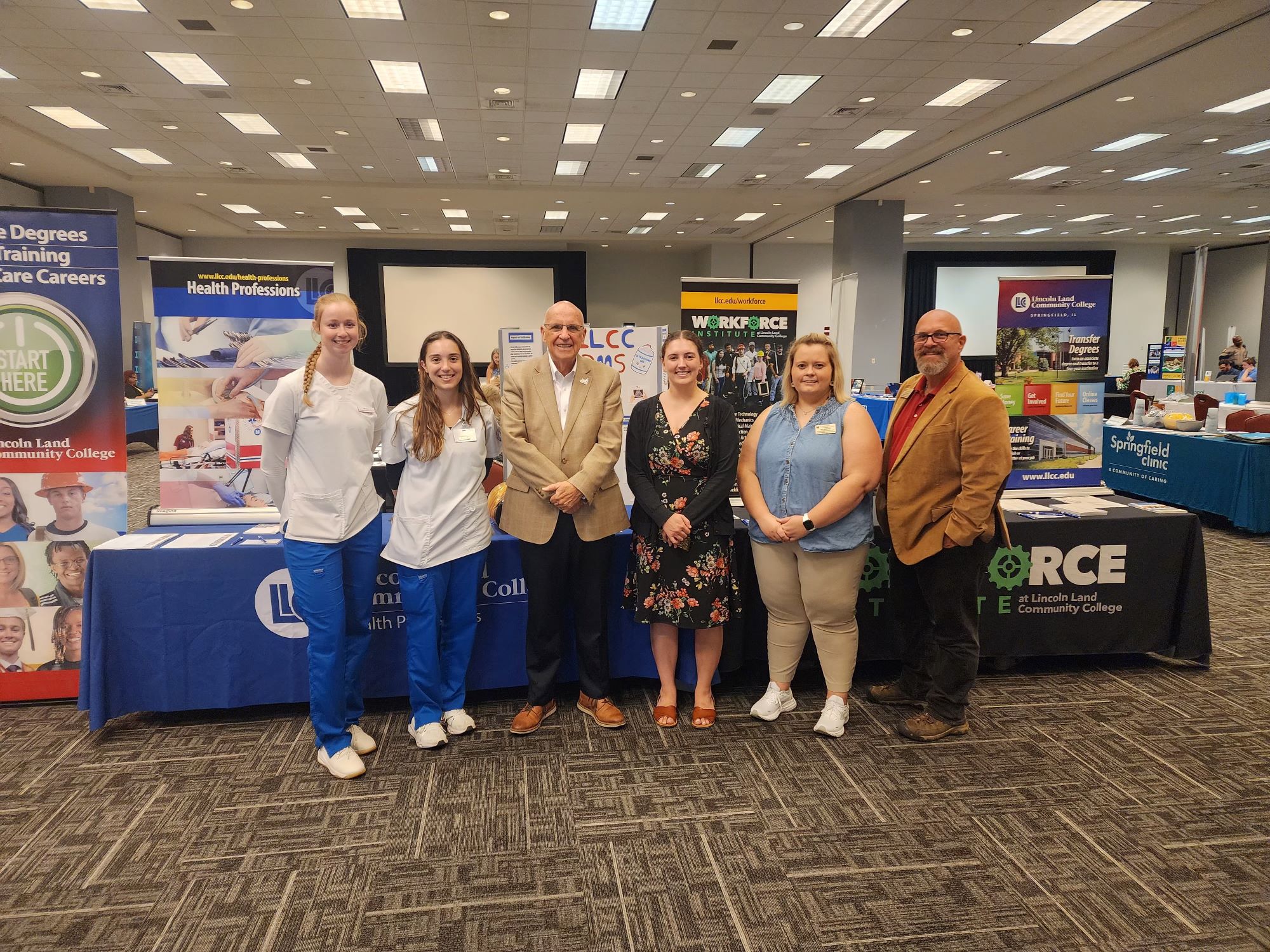 LLCC Team standing in front of the LLCC table at the Chamber Job Fair.