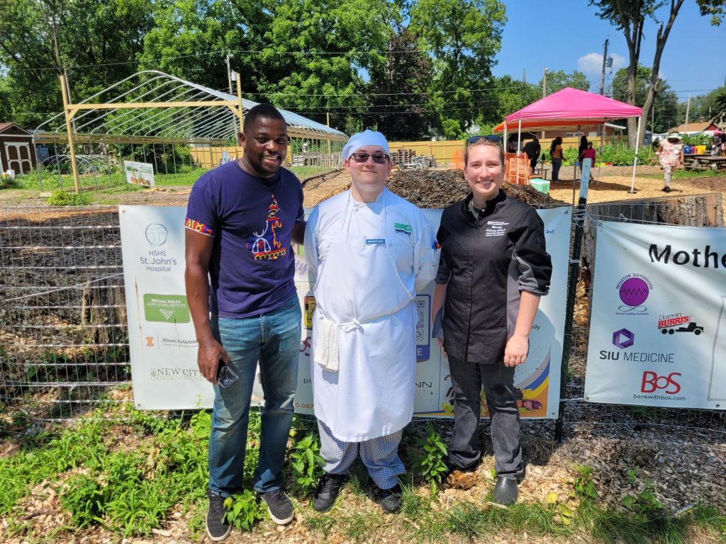 Channing Fullaway-Johnson posing with a student and director of Motherland Gardens.