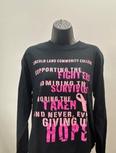 Black long sleeve tshirt with pink lettering that reads, "Lincoln Land Community College, supporting the fighters, admiring the survivors, mourning the taken and never, ever giving up hope.