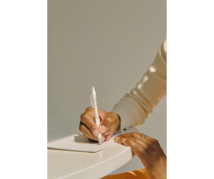 A woman's hand writing in a journal.