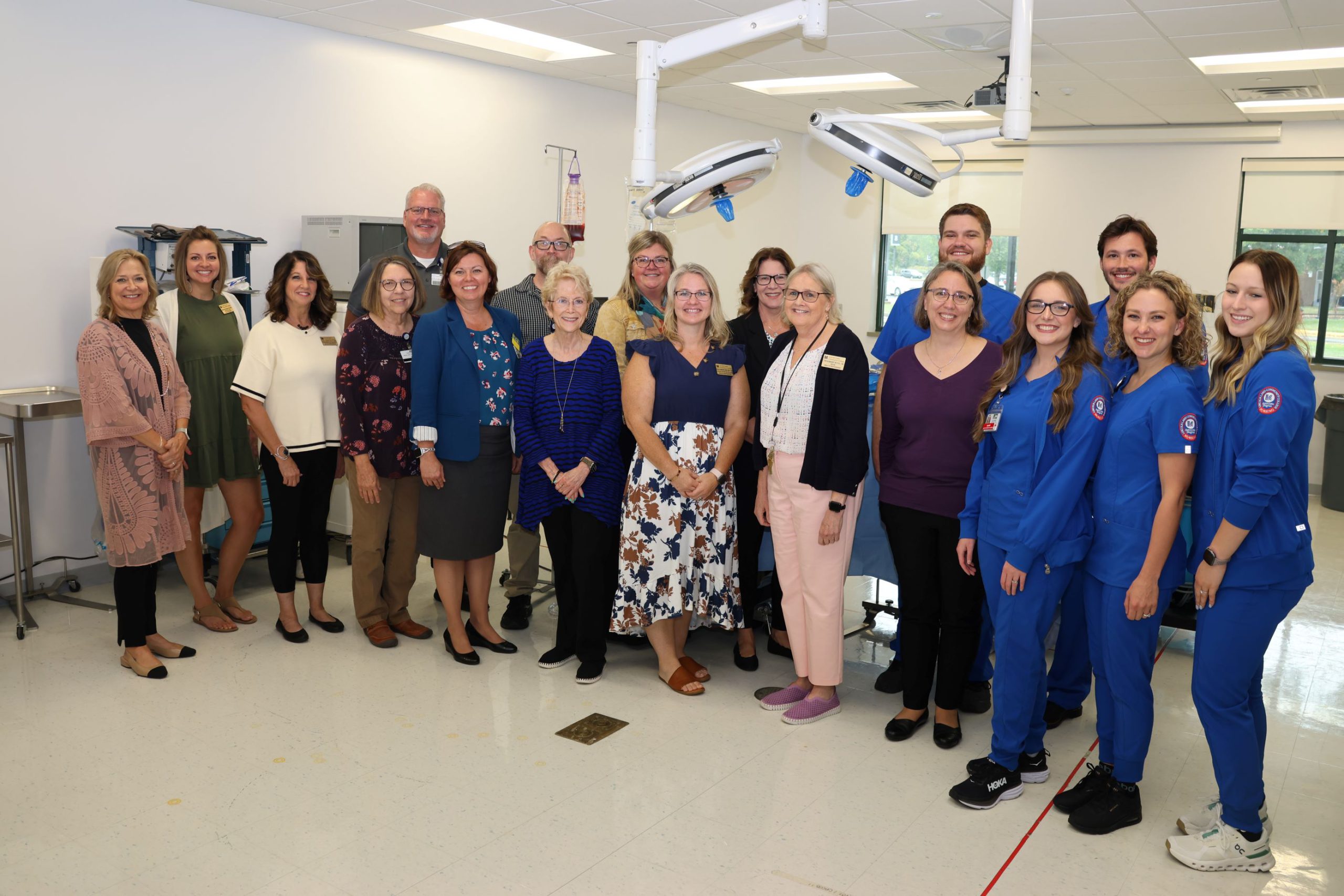 A group of people standing in the simulted operating room at LLCC.