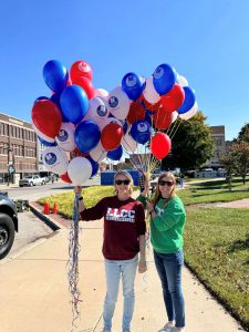 Keri Mason and Katie McDannald holding bunches of LLCC balloons.