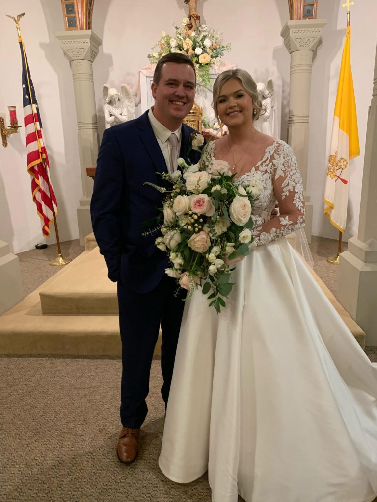 A bride and groom posing for a wedding photo.